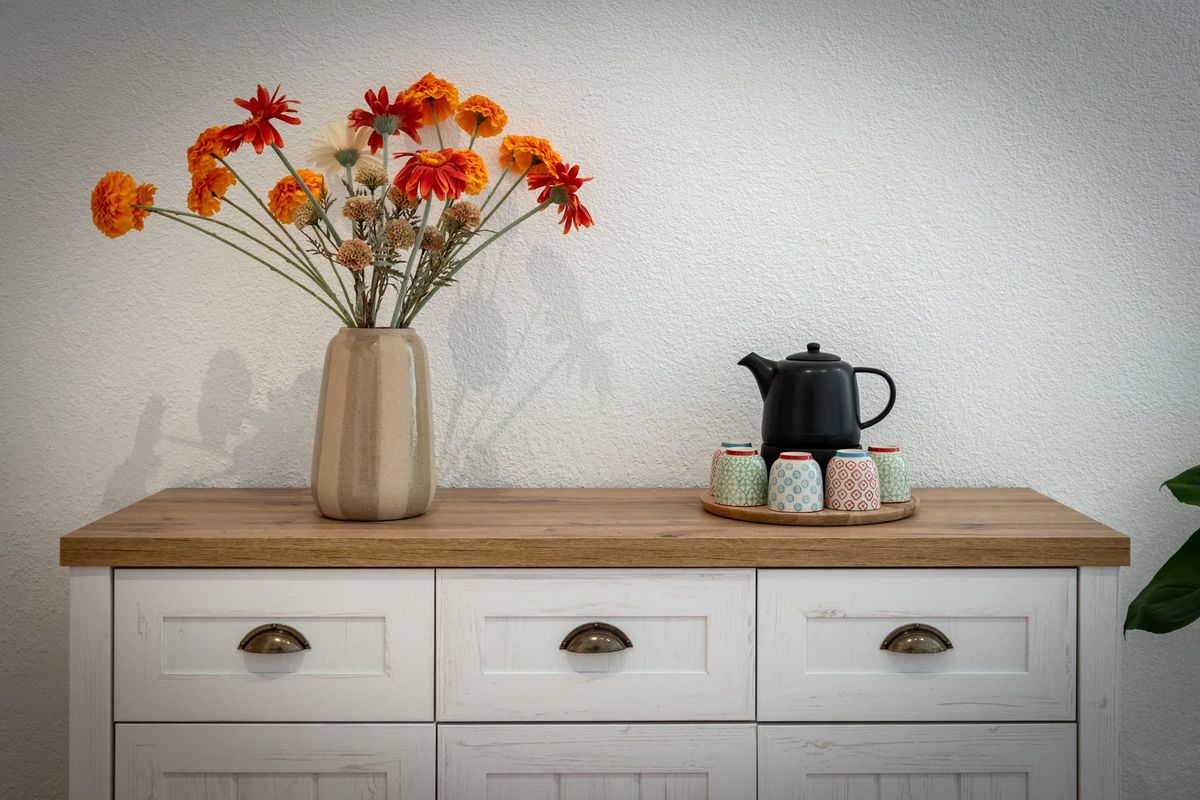 Kommode mit Blumen und Teekanne im Harmonie Studio
