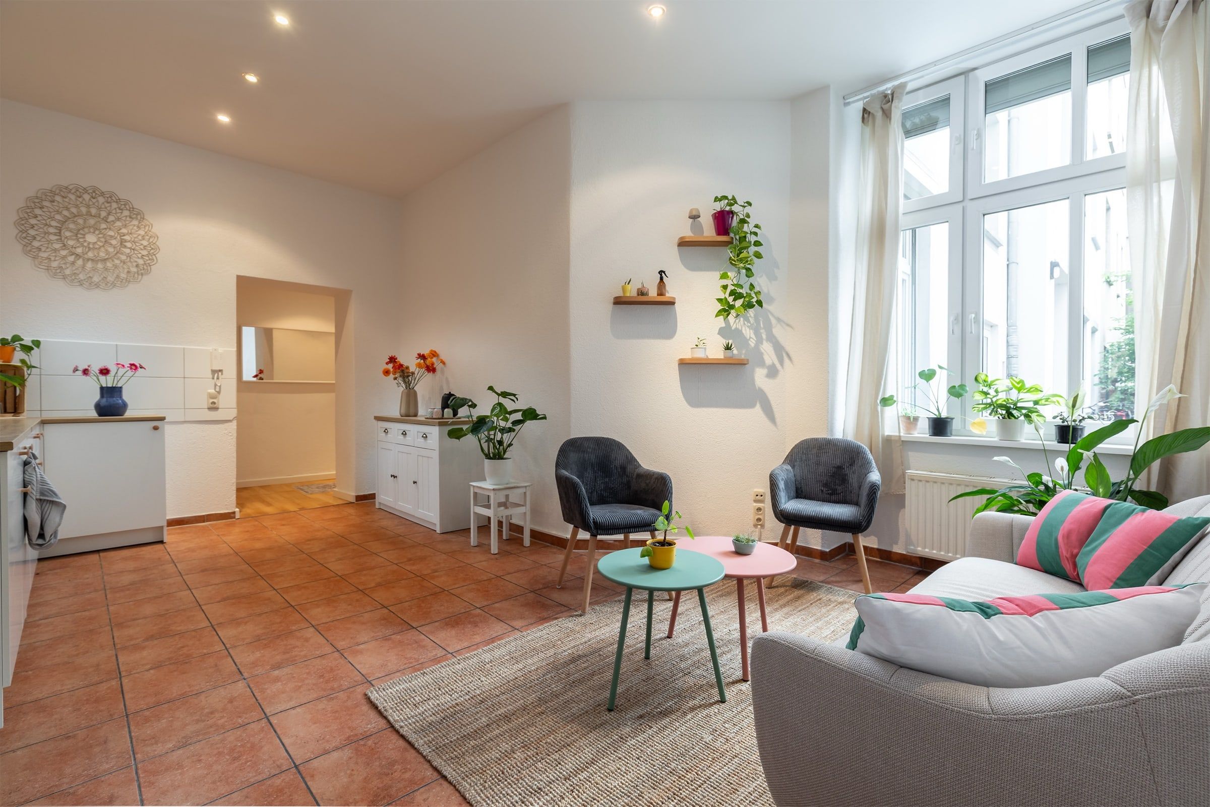 Helle Lounge im Harmonie Studio mit Sofa, Sesseln, Pflanzen und großem Fenster