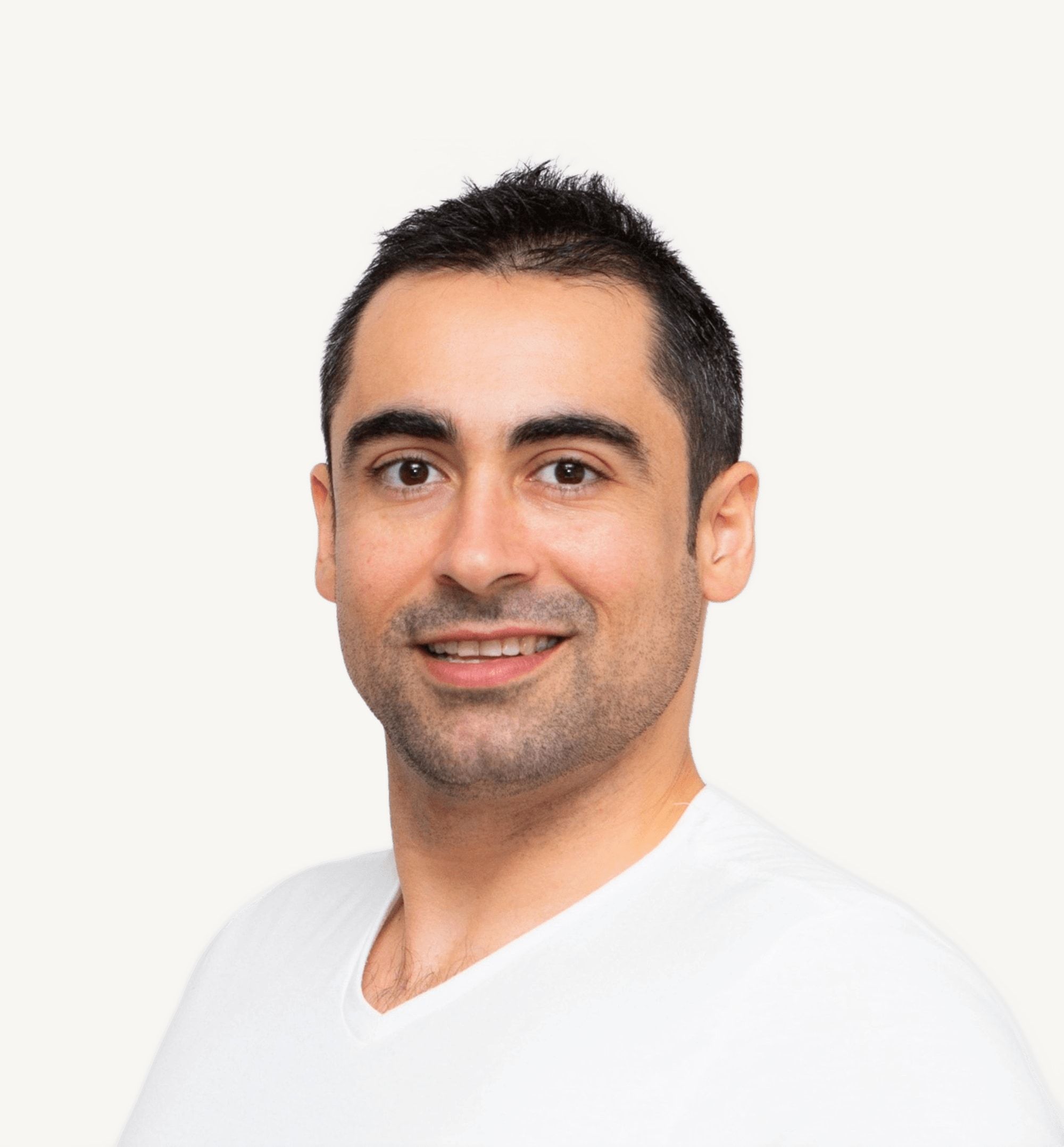 Portrait of Miguel, smiling against a light background